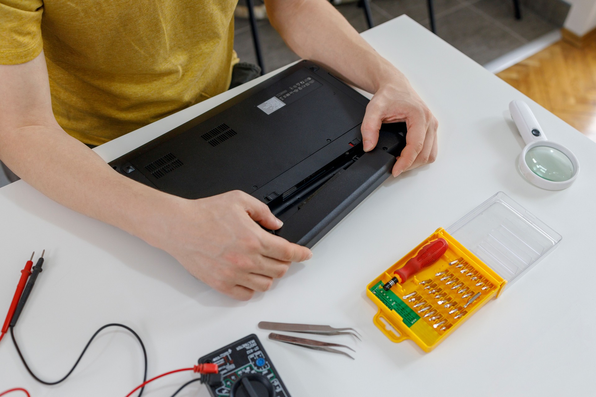 Person disassembling a laptop